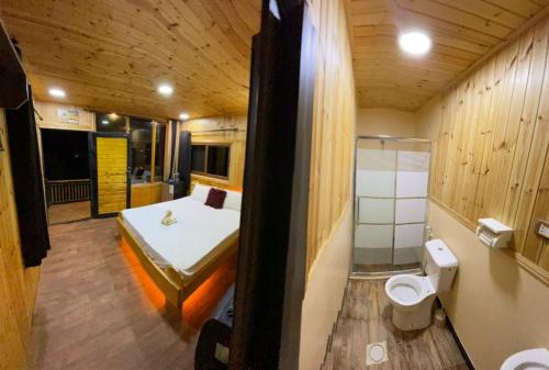 a small room with a bed and a toilet at Ajloun Wooden Huts اكواخ عجلون الخشبية Live amid nature in Umm al Manābī‘