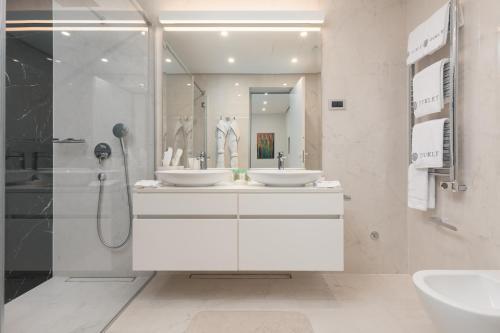 a bathroom with two sinks and a shower at Dukley Hotel & Resort in Budva