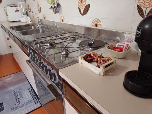 a kitchen with a stove and a sink with some food at Risveglio al Sole in Ragusa