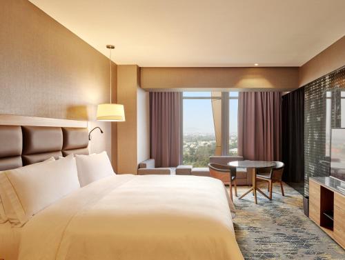 a hotel room with a large bed and a table at Fiesta Americana Viaducto Aeropuerto in Mexico City