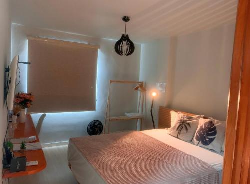 um pequeno quarto com uma cama e uma janela em LOFT aconchegante no Centro de Macaé, Wifi, Ar condicionado e Cozinha completa em Macaé
