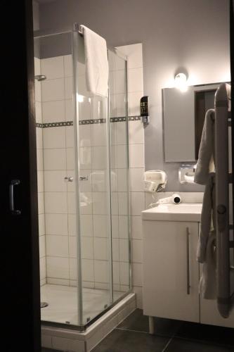 uma casa de banho com uma cabina de duche em vidro e um lavatório. em Bar-Bistro-Hotel DOK em Steenbergen
