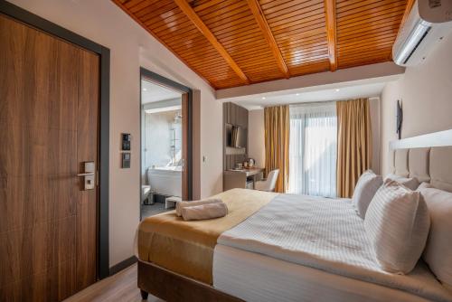 a bedroom with a large bed with a wooden ceiling at Magia Hotel - Spa & Wellness in Avcılar