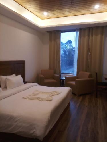 a hotel room with a bed and a window at Namastasya in Solan
