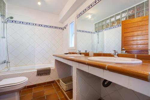 łazienka z 2 umywalkami, prysznicem i toaletą w obiekcie Villa Lucila w Corralejo