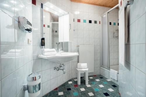 een witte badkamer met een wastafel en een douche bij Karnischer Hof in Sankt Stefan an der Gail