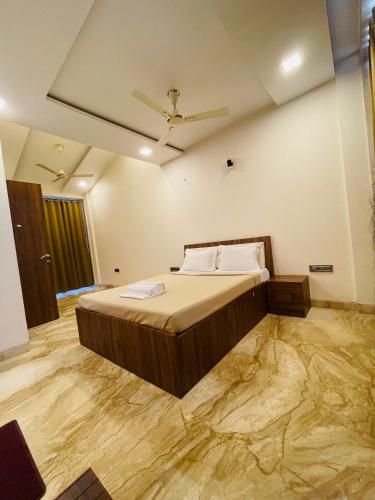 a bedroom with a large bed with a wooden floor at Prime Villa in Lonavala