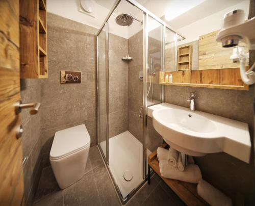 ein Bad mit einem WC, einem Waschbecken und einer Dusche in der Unterkunft TH La Thuile - Planibel Residence in La Thuile