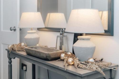 two lamps on top of a table with a mirror at Woodvale Retreat in Harpsden