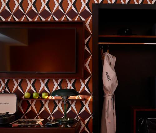 a room with a shelf with a tv and some apples at Brown Acropol, a member of Brown Hotels in Athens