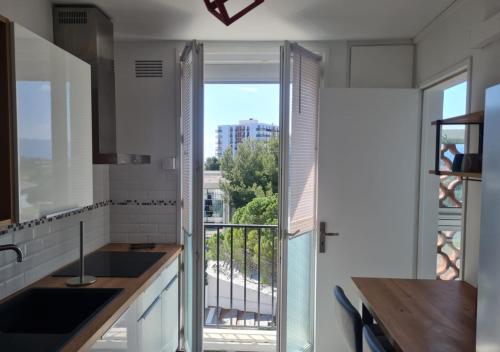 a kitchen with a view of a balcony at Escapade Montesquieu in Perpignan