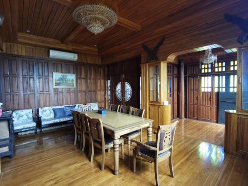 a dining room with a table and chairs at Thai traditional wooden house in Ban Nong Bu