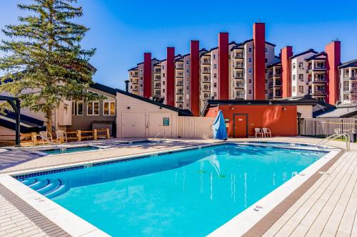 a swimming pool in front of a tall building at Torian Plum Creekside II in Steamboat Springs