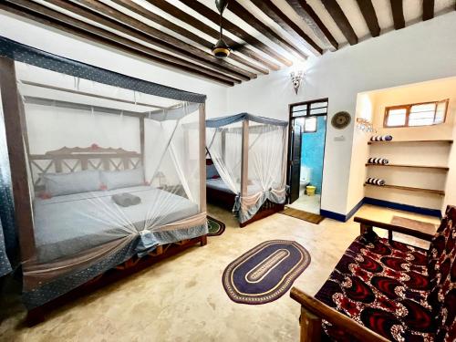 a bedroom with a canopy bed and a hammock at Chikachika Beach B&B in Nungwi