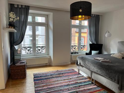 a bedroom with a bed and two windows and a rug at Stilvolle Altstadtwohnung mit 2 Schlafzimmern in Koblenz