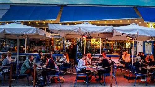 un grupo de personas sentadas en las mesas fuera de un restaurante en Centrally Located 4 Room Apartment en Copenhague