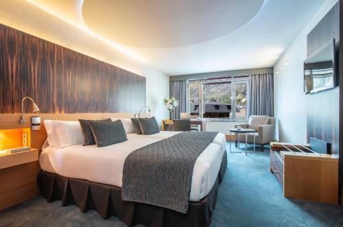 Hotel Starc by Pierre & Vacances Premium في أندورا لا فيلا: غرفه فندقيه سرير وتلفزيون