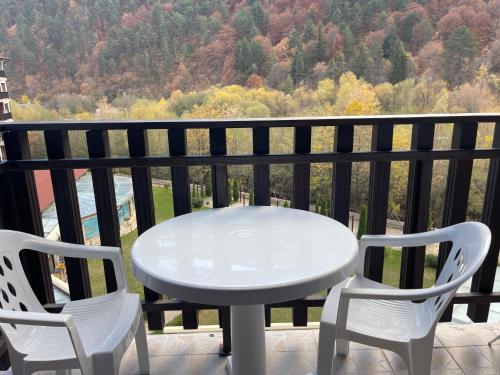 Una mesa blanca y dos sillas en un balcón. en Мия 2 Спа хотел Свети Спас, en Velingrad