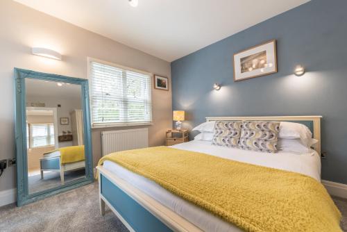 a bedroom with a large bed and a mirror at Heidi's Grasmere Lodge in Grasmere
