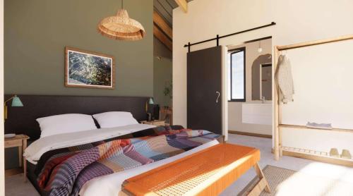 1 dormitorio con cama y banco. en untether on Olive View en Wellington