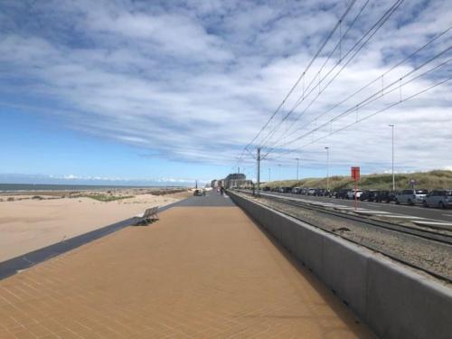 a bridge over a beach with cars parked on it at Studio met frontaal zeezicht in Ostend