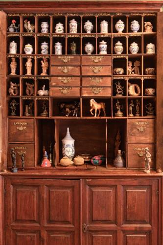 a large wooden cabinet filled with lots of vases at Hotel Rural Las Longueras in Agaete