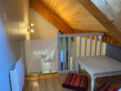 Cette chambre est dotée d'un escalier et d'un plafond en bois. dans l'établissement Appartement style chalet à Saint Lary Soulan., à Saint-Lary-Soulan