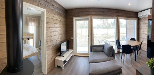 um quarto com um sofá, uma televisão e uma mesa em Sankivillat em Oulu