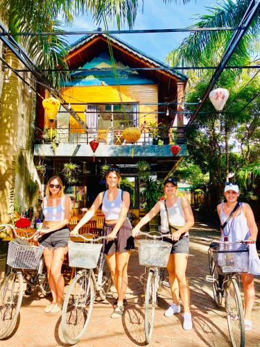 a group of women riding bikes down a street at Asahi Villa Tam Coc in Ninh Binh
