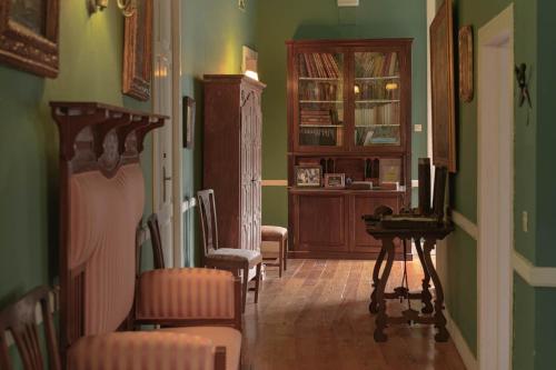 a living room with green walls and a table and chairs at Hotel Rural Las Longueras in Agaete