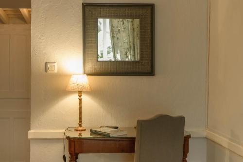 a desk with a lamp and a chair in a room at Hotel Rural Las Longueras in Agaete