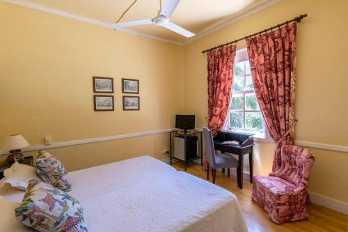 a bedroom with a bed and a chair and a window at Hotel Rural Las Longueras in Agaete