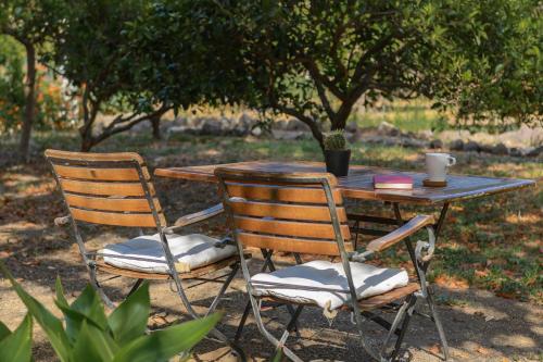 a wooden table with two chairs and a table with a cup at Hotel Rural Las Longueras in Agaete
