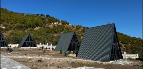 a group of triangular buildings with a mountain in the background at Green Villa Resort Small Gray in Dilijan