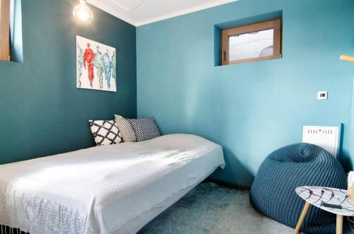 a bedroom with a bed and a blue wall at Bodensee-Apartment SeeZeichen No 26 in Bodman-Ludwigshafen