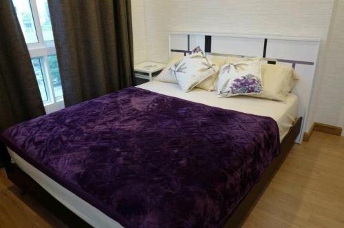 1 dormitorio con cama morada y almohadas en Gsuite Glamorous Apartment, en Bangkok