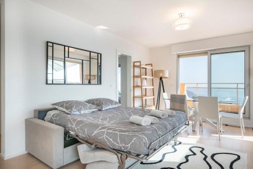 1 dormitorio con 1 cama con espejo y silla en Baie Roquebrune, Vue Mer, Parking Gratuit - AJ en Roquebrune-Cap-Martin
