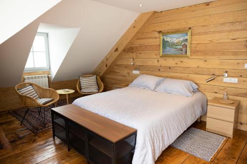 a bedroom with a bed and a wooden wall at LE 41 AVENUE FOCH in Luchon