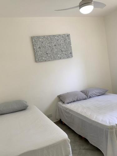 1 dormitorio con 2 camas y una foto en la pared en Apto Frente ao Mar Asturias, en Guarujá