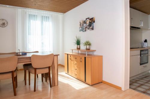 eine Küche mit einem Tisch und Stühlen im Zimmer in der Unterkunft Studio Neptun (im Zentrum von Bad Ragaz) in Bad Ragaz