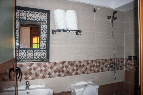 a bathroom with a sink and a toilet and a mirror at Hôtel Restaurant Ali in Midelt