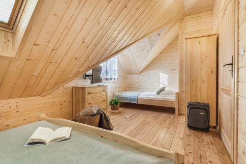 1 dormitorio en una cabaña de madera con cama y libros en Pienińska Przystań en Kluszkowce