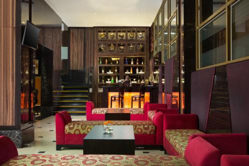 a lobby with red chairs and a bar at Best Western Plus Makassar Beach in Makassar