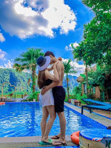 a man and a woman standing in front of a pool at Tam Coc Sky Bungalow in Ninh Binh