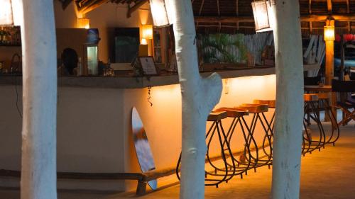 a bar with tables and chairs in a room at The Mida Creek Hotel in Watamu