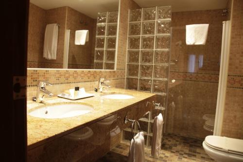a bathroom with two sinks and a toilet at Hotel Iris in Granollers