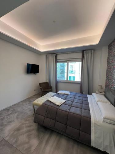 a bedroom with a large bed and a tv at Relais Vittorio Veneto - Luxotel & Apartotel in Salerno