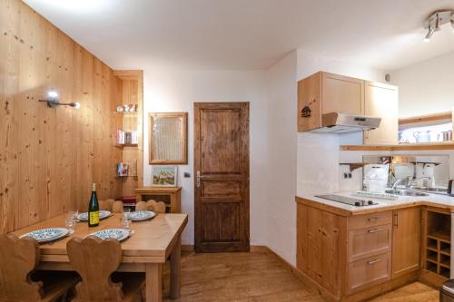 a kitchen with a wooden table and a wooden door at Paradis in Chamonix