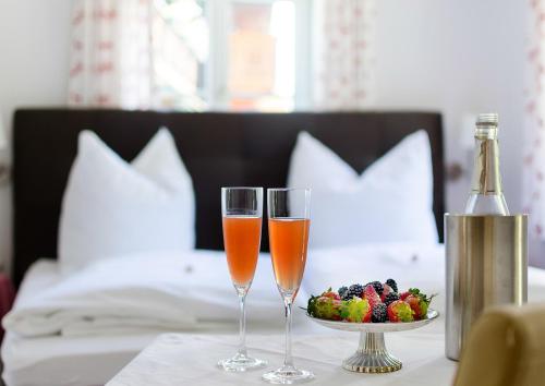 two glasses of champagne and a bowl of fruit on a table at Haus Mayerhofer in Sankt Gilgen