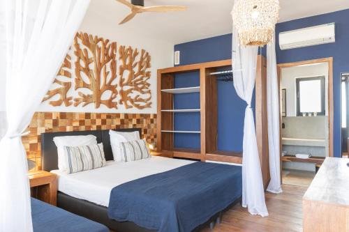 1 dormitorio con cama y pared azul en beachhouse MIMA, en Saly Portudal